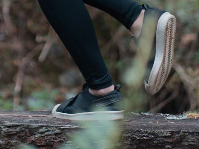 Athlete's feet in sneakers finding balance on a dark floor.